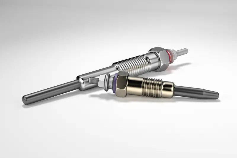 Two glow plugs showing metallic design with ribbed bodies, hexagonal bases, and terminal connections